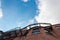 Extreme upward view looking through metal grate balcony and fire escape on an old brownstone, blue sky copy space