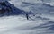 Extreme winter sport. Young pro snowboarder walks uphill in the halfpipe snow park. Teenager in blue white and black jacket is