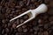 Extremely close-up of coffee beans spilling out of wooden scoop, selective ficus