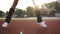 Extremely close up footage of athletic legs of a sportswoman doing cross feet jumps and squats. Girl wearing black golf