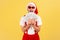 Extremely excited happy gray bearded man in santa claus hat and stylish sunglasses holding fan of dollars, giving money on