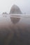 Extremely foggy view of Haystack Rock in Cannon Beach Oregon during the morning