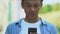 Extremely glad African-American boy with smartphone, surprised lottery winner