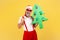 Extremely happy excited gray bearded man in santa claus hat holding paper christmas tree showing rock and roll gesture, having fun