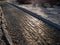 Extremely slippery footpath covered with melting snow and visible frozen ice footprints after heavy snowing in city in winter. Icy