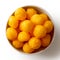 Extruded puffed cheese balls in white ceramic dish isolated on w