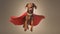 An exuberant brown dog with a red superhero cape mid-leap, tongue out, embodying joy and playful heroism against a neutral