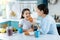 Exuberant little girl eating cookies with her mom