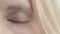 Eye of blonde girl changes color. Close up