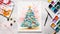 an eye-catching holiday scene with a Christmas tree drawing placed on a colorful table