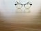 Eye Glass Frame Openly Placed over Wooden Table Surface Under Day Light Glow