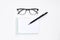 Eye glasses, blank notepad, and mechanical pencil