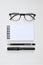 Eye glasses, blank notepad, pen, and mechanical pencil