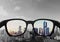 Eye glasses looking to city view, focused on glasses lens