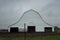 Eye-level gloomy shot of an old white barn on a cloudy day