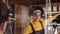 Eye Level Medium Close up, Female African coffee shop owner wearing face visor welcoming a customer