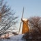 Eye-level shot of the windmill of Hoofddorp near trees in winter, Holland, Netherlands