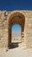 Eye-level vertical shot of an arch in the ruins of an old landmark