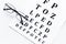 Eye test, eye examination. Glasses with transparent optical lenses on eye test chart on white background top view