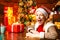 Eye winking blonde beautiful woman in Santa`s hat at winter holiday background. Merry christmas and happy new year. It