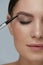 Eyebrow makeup. Beauty model shaping brows with brow pencil