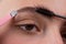 Eyebrow makeup. Macro close up of brows. Woman brushing brows with brows brush closeup. Microblading, modeling brows.