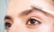 Eyebrows close up. Beautiful girl applies brow gel to her eyebrow. Close up portrait of young caucasian woman doing her