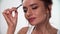 Eyebrows Makeup. Woman combing eyebrow with brush closeup