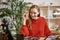 Eyebrows modeling. Smiling and young blogger wearing red sweater modeling her eyebrows while recording tutorial video