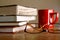 Eyeglasses, coffee mug and pile of books