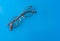 Eyeglasses with cracked lens on shiny blue background