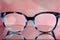 Eyeglasses Glasses with Bifocals and Black and blue Frame smudged view agaist a blurry pink  background with white hearts. Blurry