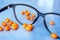 Eyeglasses with heap of orange pills on blue background.