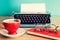 Eyeglasses over notebook, coffee cup and typewriter