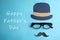 Eyeglasses, paper mustache and hat on blue background, flat lay. Happy father`s day