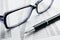 Eyeglasses and Pen on Top of Report Papers