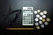 Eyeglasses, pencil, calculator and coins on a wooden table