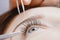 Eyelash extension procedure. Woman master making fake long lash