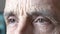 Eyes of an elderly man close-up. Three quarter portrait. A grown man looks away.