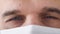 Eyes of tired doctor wearing medical mask macro footage