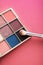 Eyeshadow palette and make-up brush on coral background, eye shadows cosmetics product for luxury beauty brand promotion and