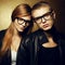 Eyewear concept. Portrait of red-haired fashion twins in black clothes