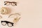 Eyewear fashion autumn collection. Trendy glasses in plastic and matallic frame on a beige background with golden leaves. Fall