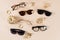 Eyewear fashion autumn collection. Trendy glasses and sunglasses in plastic and matallic frame on a beige background with golden