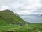 Eysturoy, Funnings kommuna. View on the town in the valley. It is surrounded by green fields, green mountains and