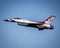 F-16 Thunderbird in flight in background of blue sky