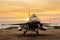 F16 falcon fighter jet on sunset background