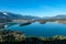 Faakersee - A drone shot of a Faaker lake in Austrian Alps. The lake is surrounded by high mountains. There is a small island
