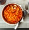 Fabes con almejas of white beans stewed with clams in clay bowl