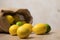 Fabric bag with lemons. Full sack of lemons on a wooden background